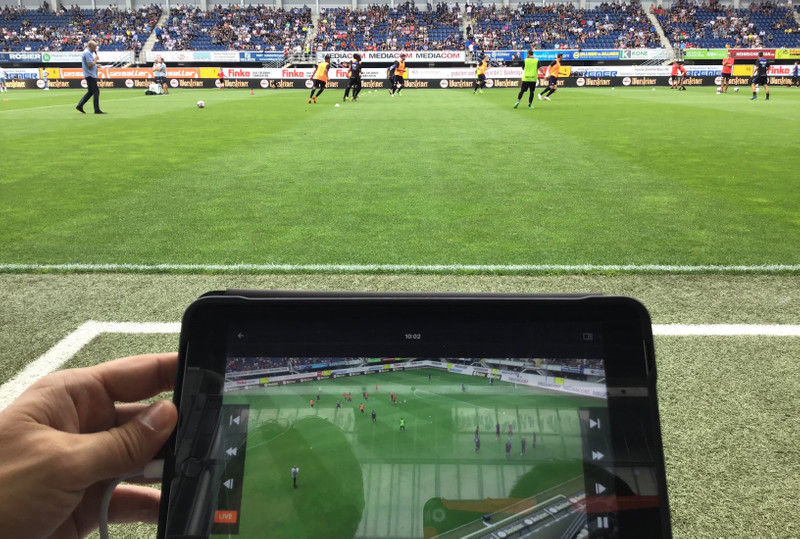 Manager watches live video on sidelines of football game
