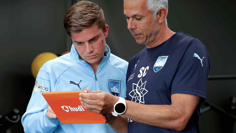 Hudl タブレットでシドニー FC 選手に分析を見せるコーチ